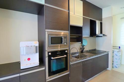 a kitchen with a stove and a microwave at Nature Home - Swiss Garden Resort Residences in Kuantan