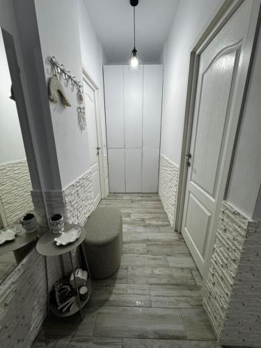 a bathroom with a shower with a chair and a door at Apartament MaGiFa Mamaia Nord in Năvodari