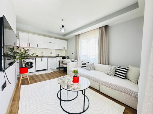 a living room with a white couch and a table at merkezde 2 odalı minimalist ev in Çiftlikköy
