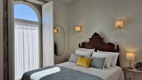 a bedroom with a bed with a large window at Casas São Tiago - Arouca, conforto e natureza in Arouca