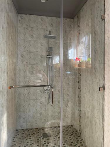 a shower with a glass door in a bathroom at Tulia Room in Dar es Salaam