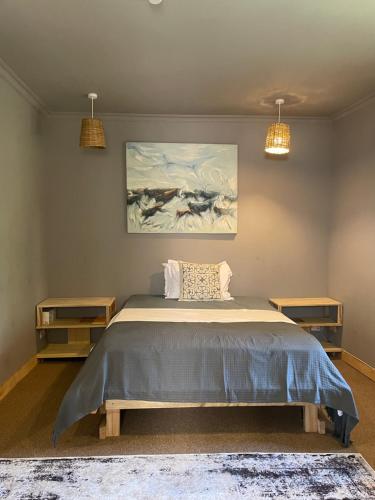 a bedroom with a bed and a painting on the wall at Tulia Room in Dar es Salaam