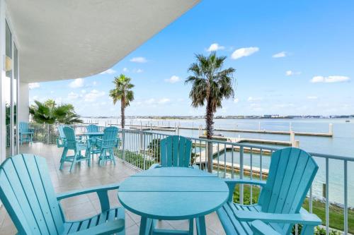 a patio with tables and chairs and the water at Caribe C104 in Orange Beach