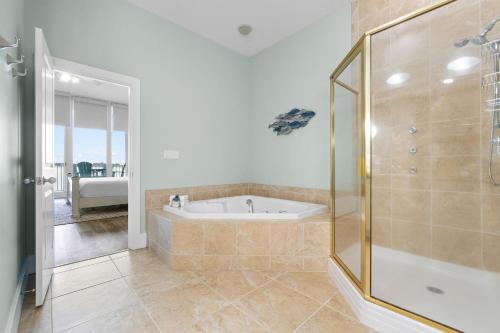 a large bathroom with a tub and a shower at Caribe C104 in Orange Beach