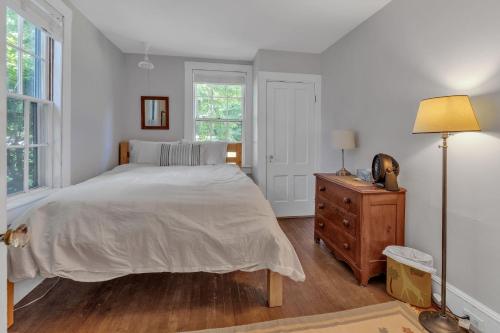 a bedroom with a bed and a dresser and window at Rustic Farmhouse home in Southwest Harbor