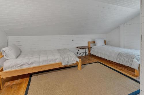 a room with two beds and a table in it at Rustic Farmhouse home in Southwest Harbor
