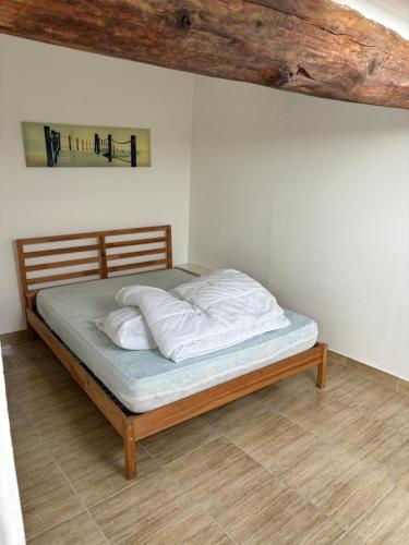 Cette chambre comprend un lit avec des oreillers blancs et un cadre en bois. dans l'établissement Apparemment proche de la mer, à Vias