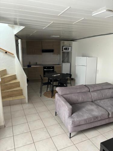 un salon avec un canapé et une table et une cuisine dans l'établissement Apparemment proche de la mer, à Vias