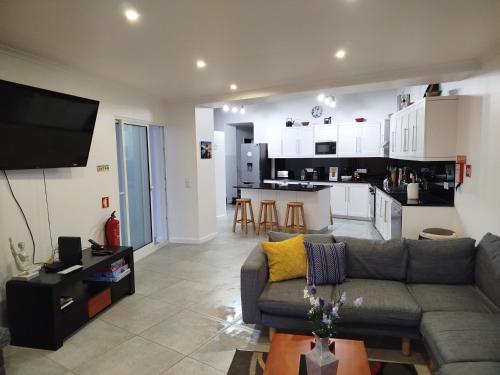 a living room with a couch and a kitchen at Pôr do Sol in Ribeira Grande