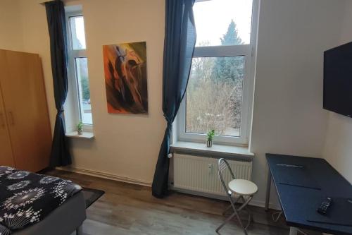 1 dormitorio con 2 ventanas, 1 cama y escritorio en Wohnung Schlossblick, en Celle