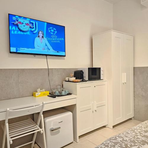a room with a desk with a tv on the wall at San Donato Policlinico BBking in San Donato Milanese