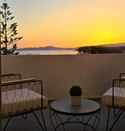 a sunset on a balcony with two beds and a table at Aphrodite Boutique Hotel in Aliki