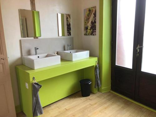 une salle de bains avec deux lavabos sur un comptoir vert dans l'établissement La Modestine, à Le Monastier sur Gazeille