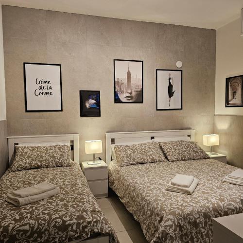 a bedroom with two beds and pictures on the wall at San Donato Policlinico BBking in San Donato Milanese
