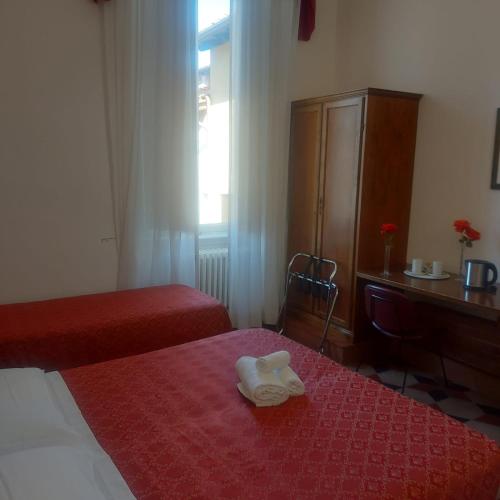 a hotel room with two beds and a dresser at Hotel Annalena in Florence