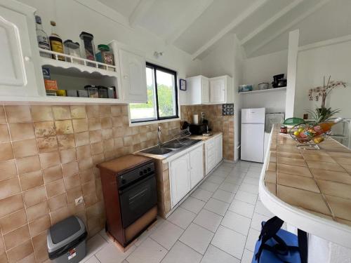 a kitchen with white cabinets and a sink and a counter at Terrasse des Manguiers : logement indépendant in Pointe-Noire