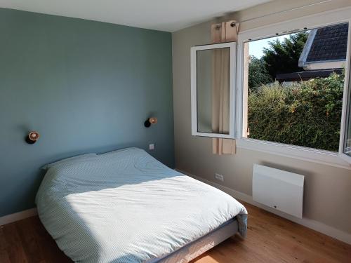 une chambre avec un lit et une fenêtre dans l'établissement Maison avec jardin, centre ville et plage à pieds, à Houlgate