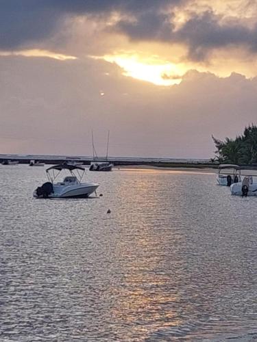a group of boats in the water at sunset at Sunshine Residence Holiday Apartments Mauritius in Poste Lafayette