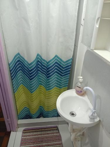 a bathroom with a shower curtain and a sink at Lolita House in Rio de Janeiro