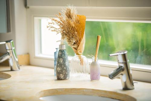 a bathroom counter with a sink with bottles and a window at Schloss Suggenstein in Sigmaringen
