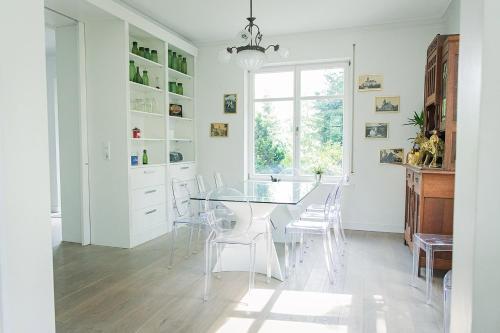 a dining room with a glass table and white chairs at Schloss Suggenstein in Sigmaringen
