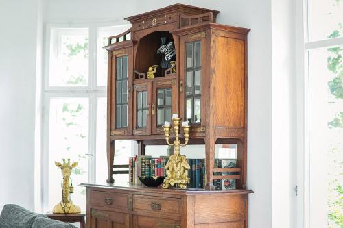 a large wooden cabinet in a room with books at Schloss Suggenstein in Sigmaringen
