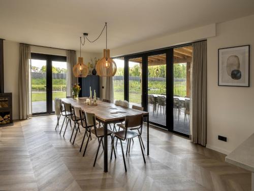 a dining room with a table and chairs at Beautiful villa on the water in Friesland in Sint Nicolaasga