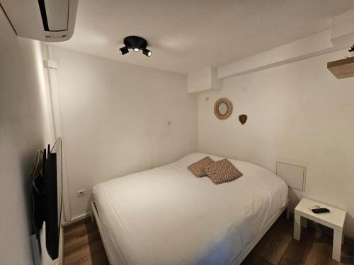 Cette petite chambre comprend un lit blanc et une télévision. dans l'établissement Studio 