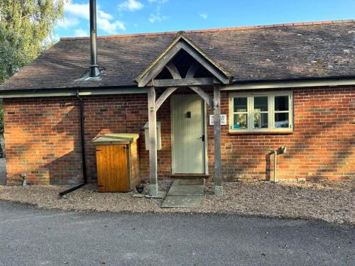 a brick house with a door and a window at The Old Cricket pavilion, Bodiam, East Sussex in Bodiam