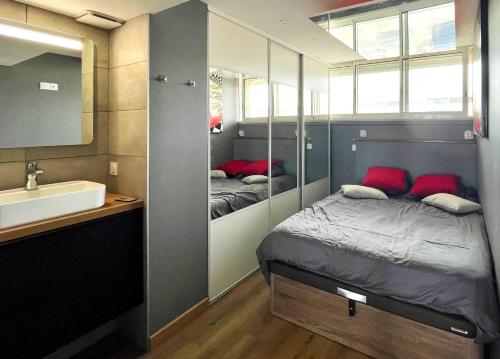 une petite chambre avec un lit et un lavabo dans l'établissement COURSIVES RED-LIGHT 108 Vue Mer, au Cap d'Agde