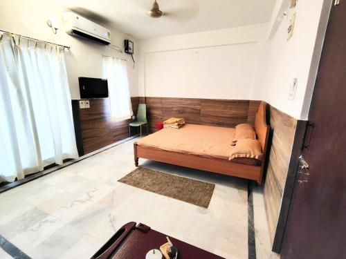 a bedroom with a bed and a tv in it at KaKaRa BEACH homestay in Puri