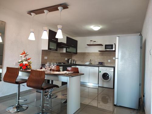 Una cocina con mesa y sillas y un refrigerador. en 206 Regalia, en Flic en Flac