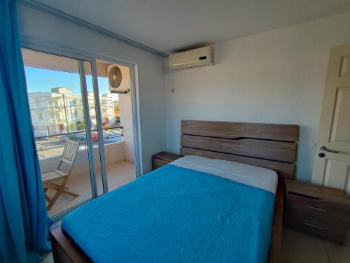 Un dormitorio con una cama azul y un balcón. en 206 Regalia, en Flic en Flac