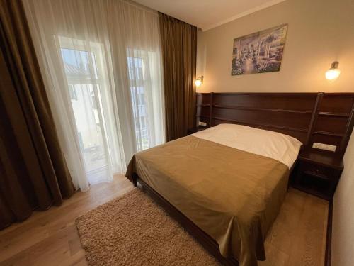 a bedroom with a bed and a large window at Green Duck Hotel in Kharkiv