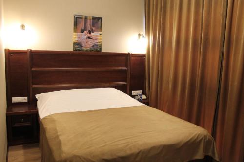 a hotel room with a bed and a curtain at Green Duck Hotel in Kharkiv