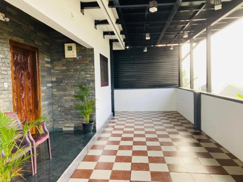 a corridor with a checkered floor in a building at CARMEL HOME STAY in Munnar
