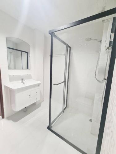a white bathroom with a shower and a sink at Star house Seaview Lanta old town in Ko Por
