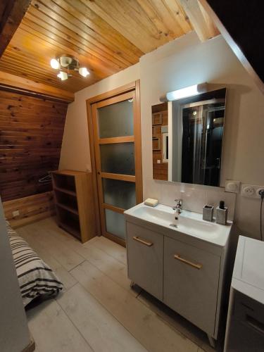 une salle de bain avec un lavabo et un miroir dans l'établissement Petit chalet avec terrasse, à Oust