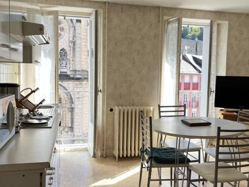 une cuisine avec une table et des chaises et une fenêtre dans l'établissement Appartement T3 chaleureux au centre de Cauterets, 4 couchages, balcon sud, proche thermes et télécabine - FR-1-234-132, à Cauterets