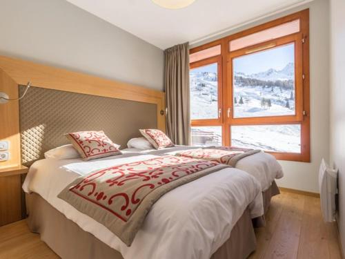 une chambre avec un grand lit et une fenêtre dans l'établissement Appartement cosy 3 chambres avec piscine, spa et parking - Arcs 1800 - FR-1-352-32, à Arc 1800