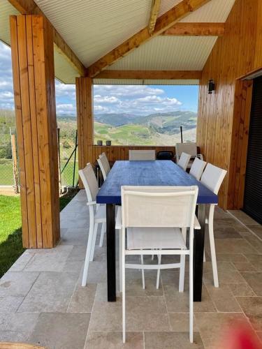 - une table bleue et des chaises blanches sur la terrasse dans l'établissement Belle villa proche de Lyon dans le Beaujolais, à Dareizé