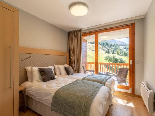 a bedroom with a bed and a large window at Duplex 4 chambres avec piscine, spa et parking aux Arcs 1800 - FR-1-352-55 in Arc 1800