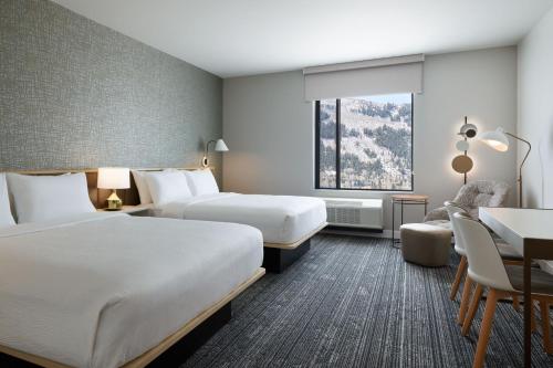 a hotel room with two beds and a desk at TownePlace Suites by Marriott Avon Vail Valley in Avon