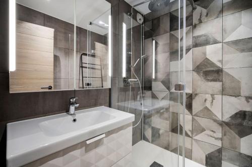 a bathroom with a sink and a shower at App d'exception 8pers, 66 m2, plein sud, confort, sauna, au calme, rénovation 2024 in Val Thorens