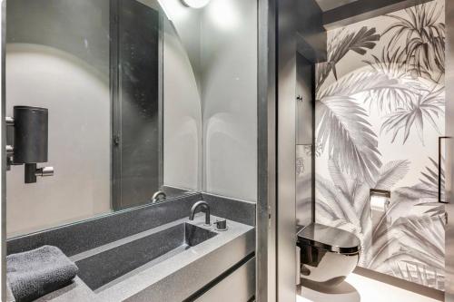 une salle de bain avec un lavabo et un miroir dans l'établissement Splendide appartement de 50m2 Paris -Montmartre, à Paris