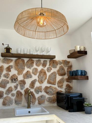 a sink in a kitchen with a stone wall at Palm Leaf Mogan in Puerto de Mogán