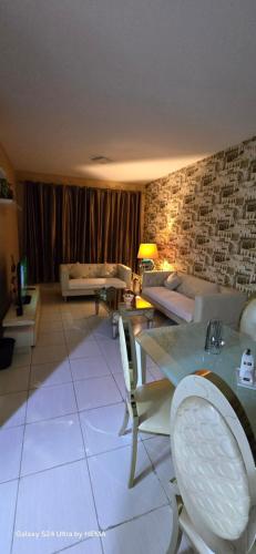 a living room with a couch and a table and chairs at شقه باطلاله شاطي عجمان in Ajman