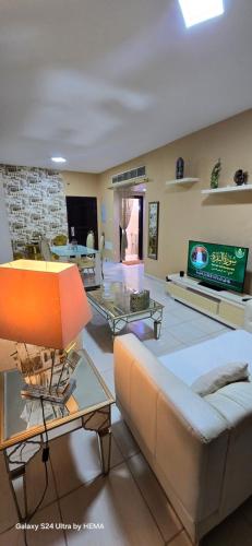 a living room with a couch and a tv at شقه باطلاله شاطي عجمان in Ajman