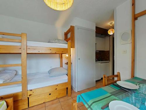 une chambre avec deux lits superposés et une table dans l'établissement Studio skis aux pieds avec parking - Montgenèvre, 650m du centre et ESF - FR-1-330D-1, à Montgenèvre