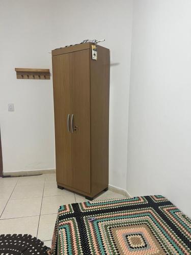a wooden cabinet in a room with a rug at Apto á 3km do inhotim in Brumadinho